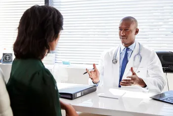doctor talking to patient at a desk