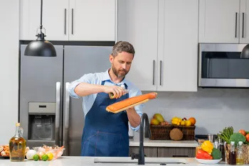 man oiling salmon in the kitchen