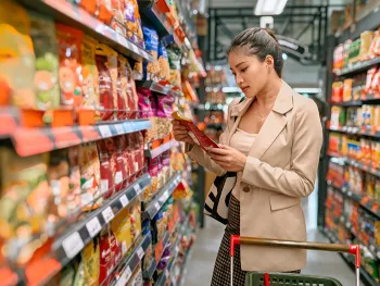 woman in grocery store looking at package of food
