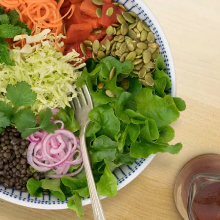 bowl of salad with dressing on side