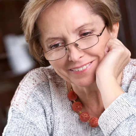 woman resting chin on hand and smiling