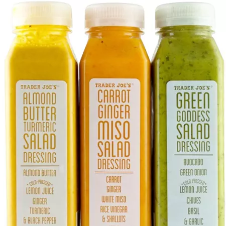 three bottles of trader joe's refrigerated salad dressing.