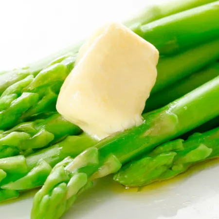 green asparagus stalks with melting pat of butter