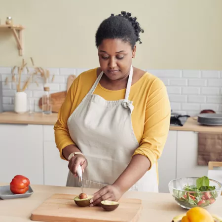Woman cutting an avocado in bright kitchen