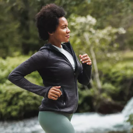 woman running along a creek