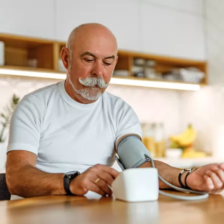 Man taking his blood pressure in the kitchen
