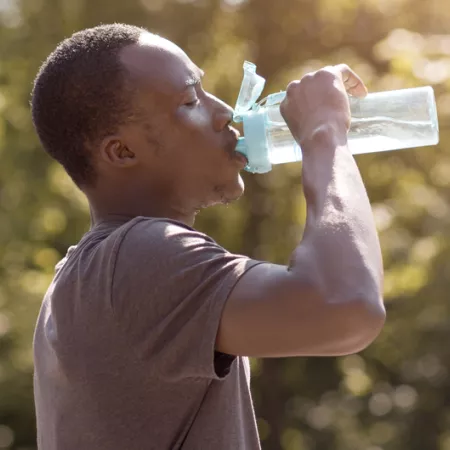 man drinking water from a reusable water bottle