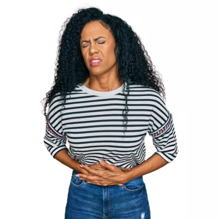 woman holding her stomach and wincing