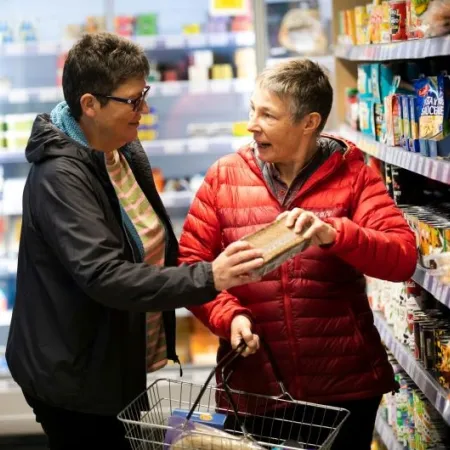 Older couple shopping together, reading food labels