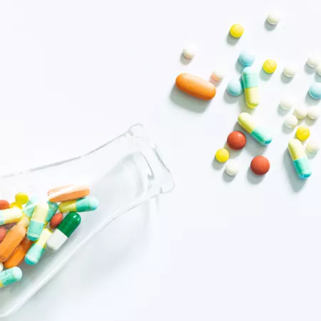 beaker spilling colorful pills