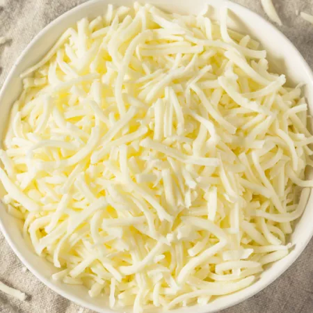 white bowl filled with light shredded cheese