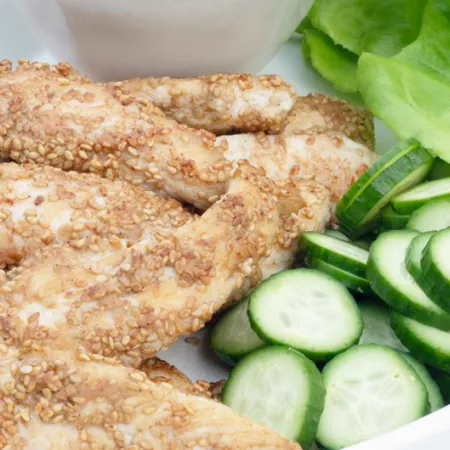 plate with lettuce cucumber and sesame chicken