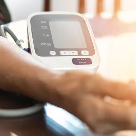 person using at at-home blood pressure monitor
