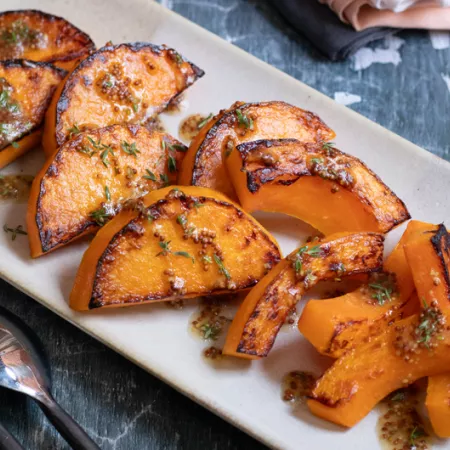white plate holding slices of cooked butternut squash