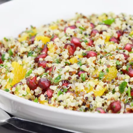 bowl of quinoa, with other chopped vegetables and herbs and pomegranate seeds