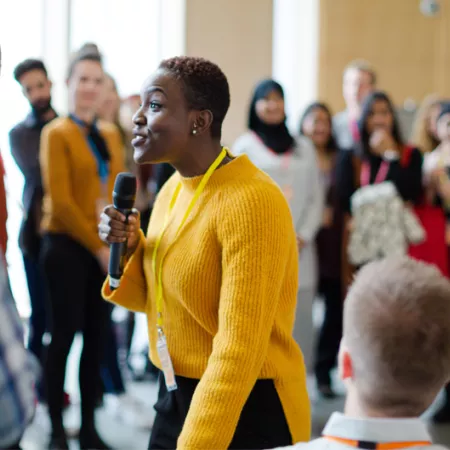 A woman speaking to a diverse group