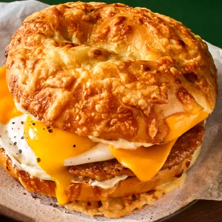 panera's asiago sausage & egg sandwich on a green background