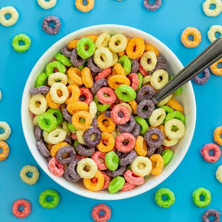 Colored breakfast cereal in a bowl on a blue background