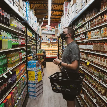 A man with a shopping basket eyeing the soda display in a supermarket