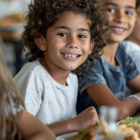 kids sitting at a table with food in front of them