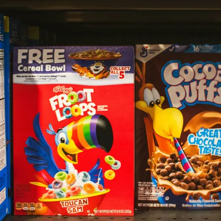 A supermarket shelf displaying boxes of brightly colored breakfast cereals.