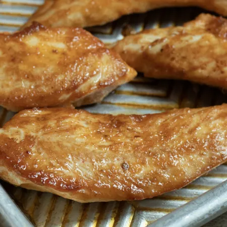 metal sheet pan with breaded chicken on it
