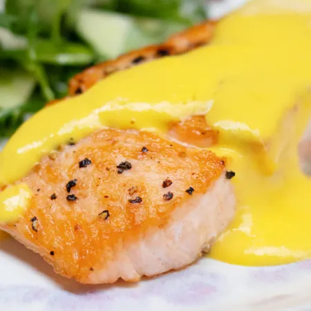 salmon filet with a yellow mango sauce on top