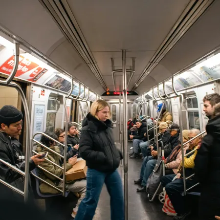 Inside a NYC subway car with prominently displayed ads