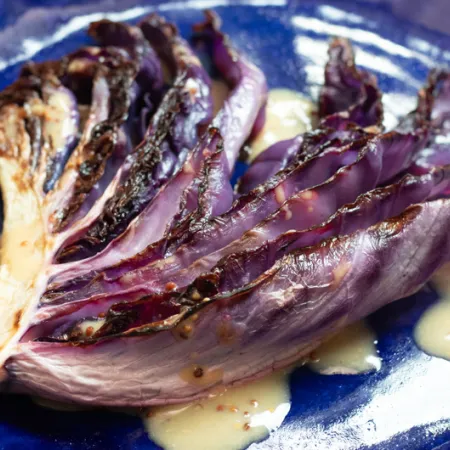 red cabbage leaf with honey mustard sauce on indigo plate