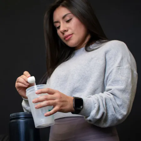 woman scooping powder into clear cup