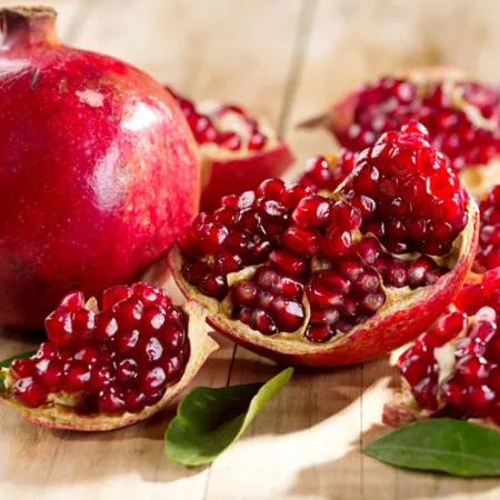 1 whole pomegranate and one split up laying next to each other