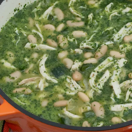 large orange ceramic pot filled with green chicken chili