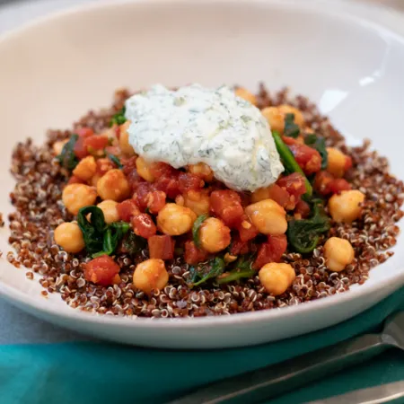 white bowl with chickpea sew topped with yourt