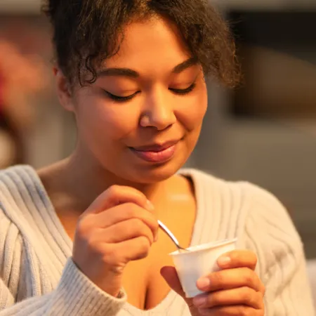 woman eating a cup of yogurt