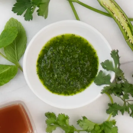 bowl of chimichurri surrounded by whole ingredients