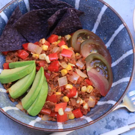 striped blue bowl with chopped vegies and avocado