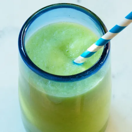 clear glass with blue rim filled with a light green drink