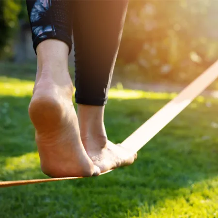 woman's feet walking on a tightrope low to the ground in a park